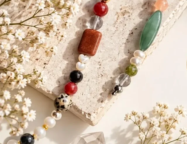 Natural stone bag charms and beads among small white flowers